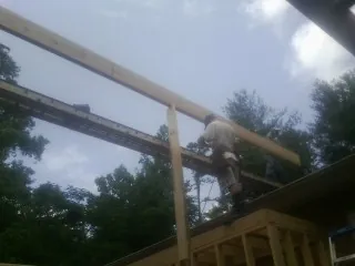 Carpenter setting a ridge beam over a new addition frame — Ice Dam Removal by Roofing Brothers in South Wellfleet