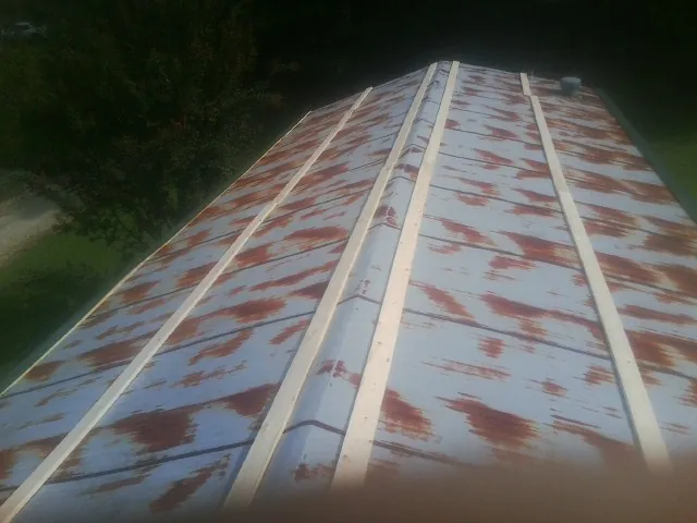 Rusted metal roof panels with new wood purlins before replacement — Storm Damage Roof Repair in South Wellfleet by Roofing Brothers