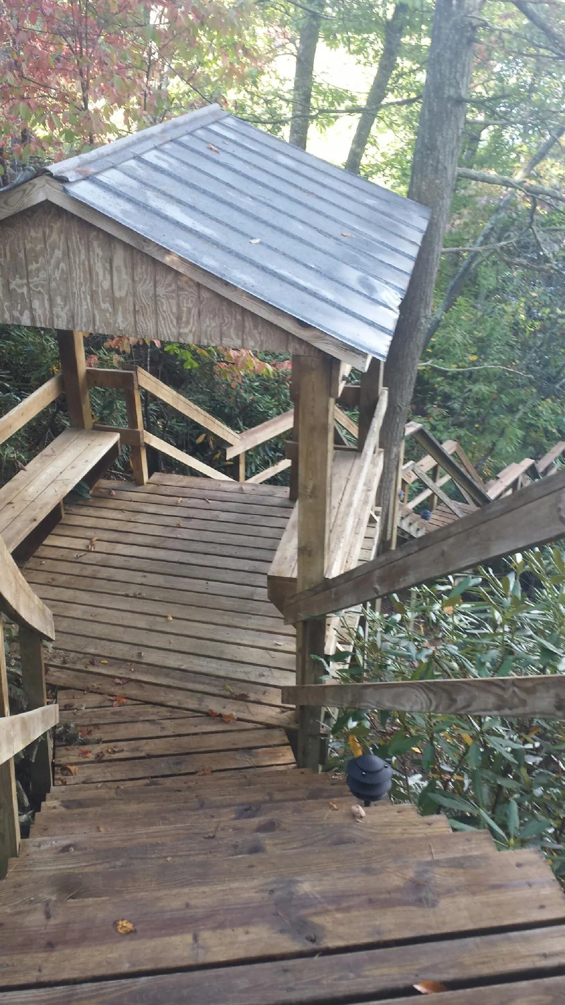 Metal roofed shelter over wooden steps on a wooded walkway — Skylight Repair & Installation work by our crew in South Wellfleet