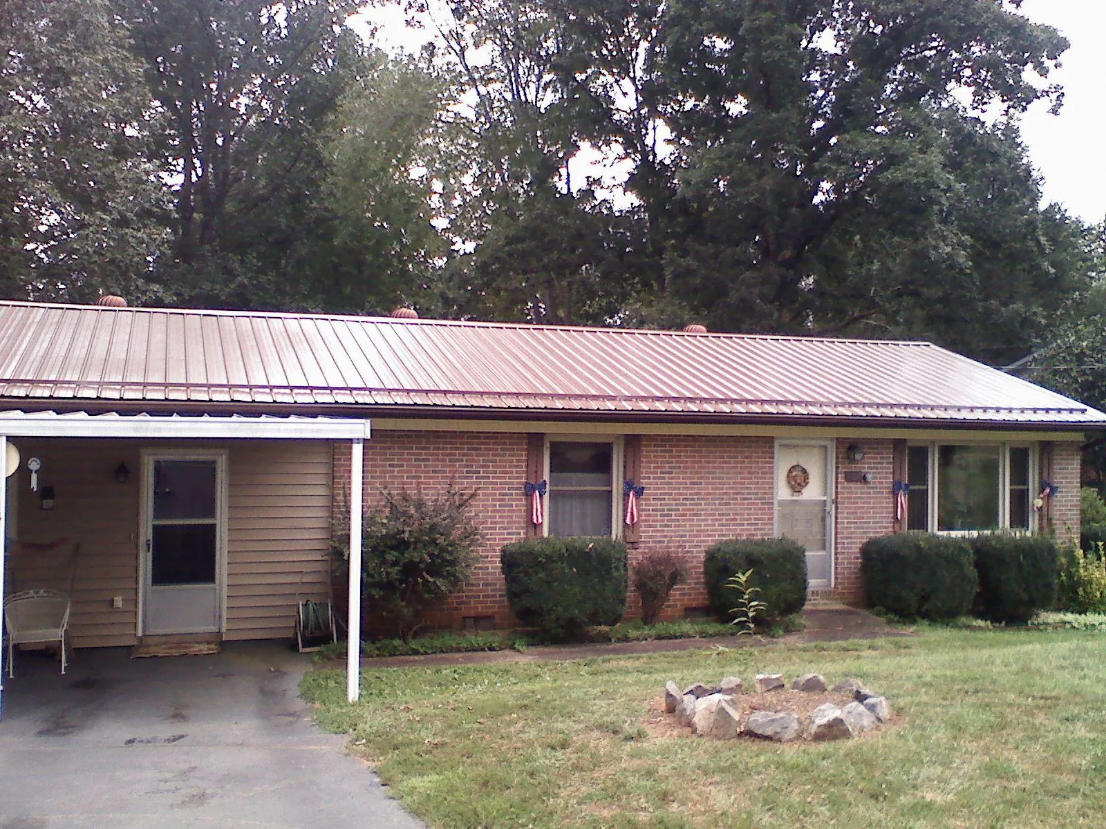 Bronze metal roof and carport on a brick ranch home — Roof Repair work by our crew in South Wellfleet